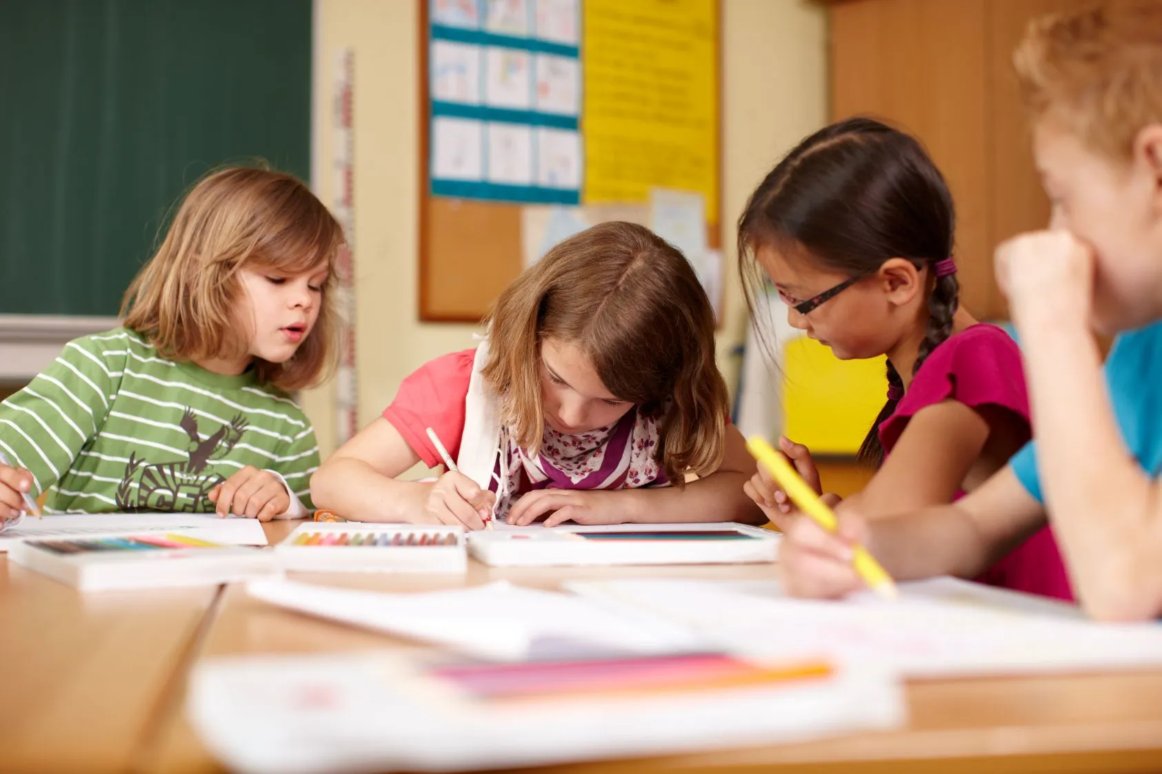 kinder schreiben an schreibtisch in schulklasse