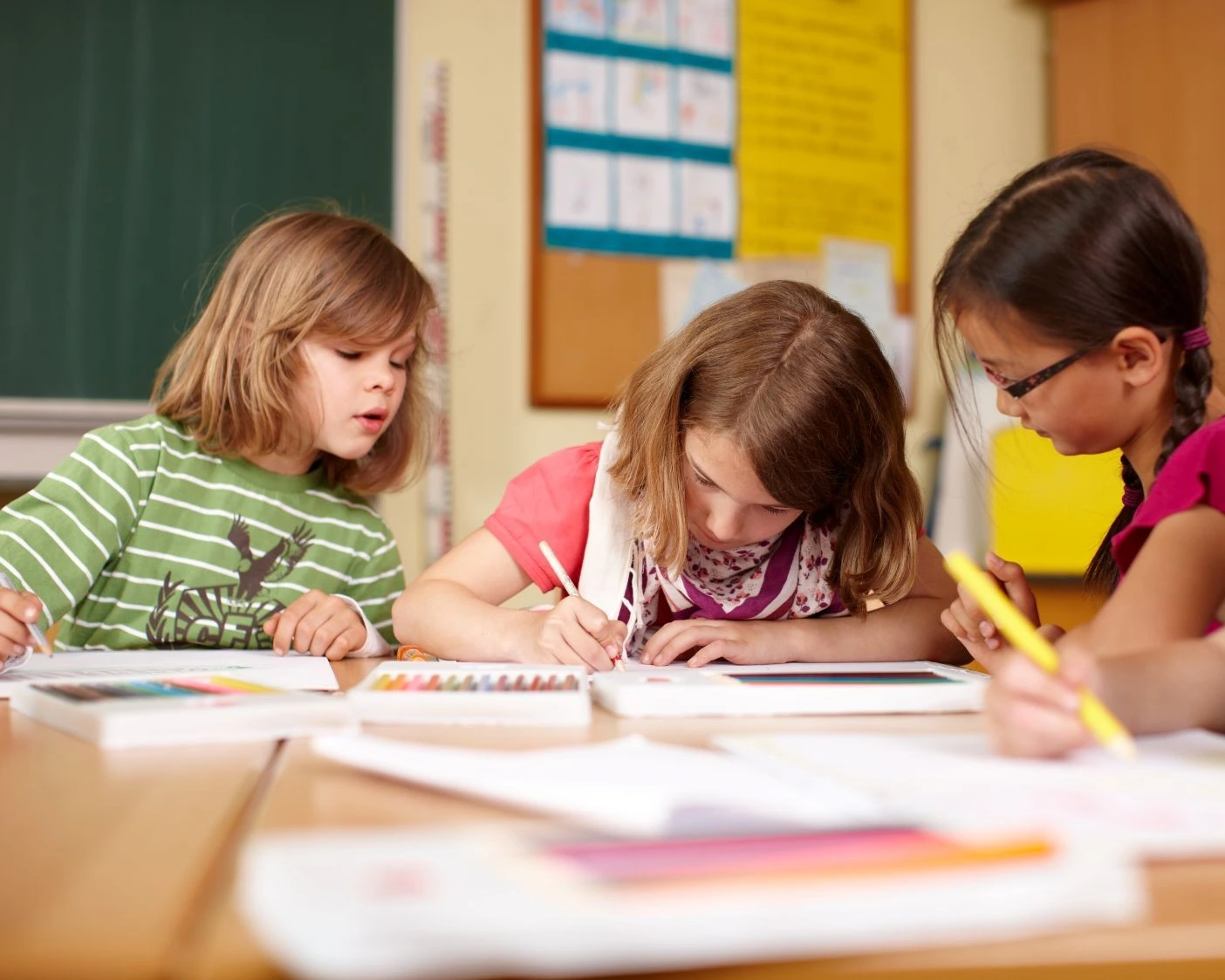 kinder schreiben an schreibtisch in schulklasse