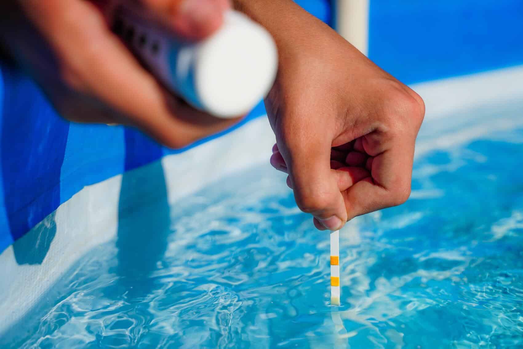 Eine Person nimmt eine pH-Wert Messung in einem Pool vor