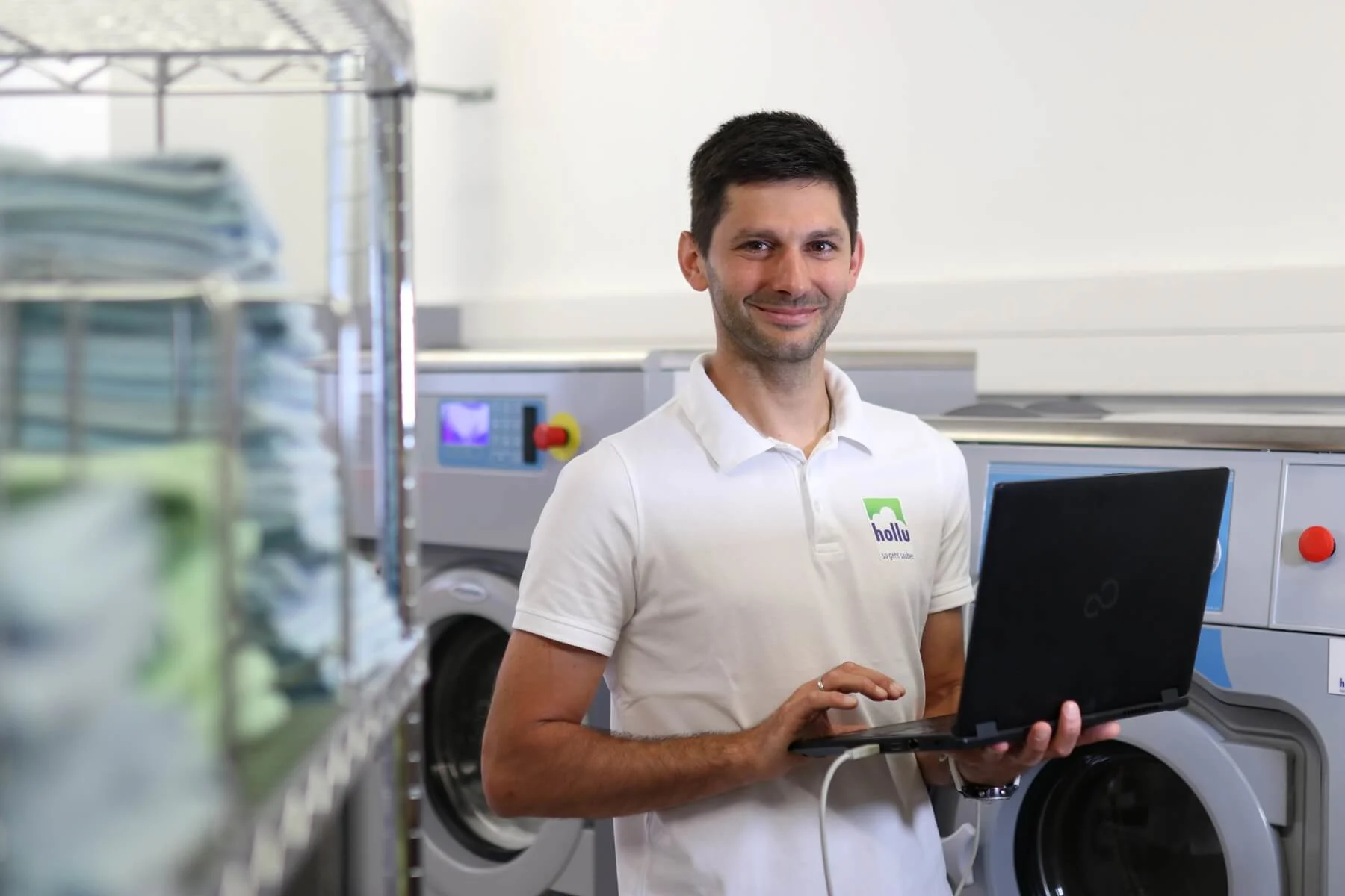 eine person mit einem laptop vor einer waschmaschine