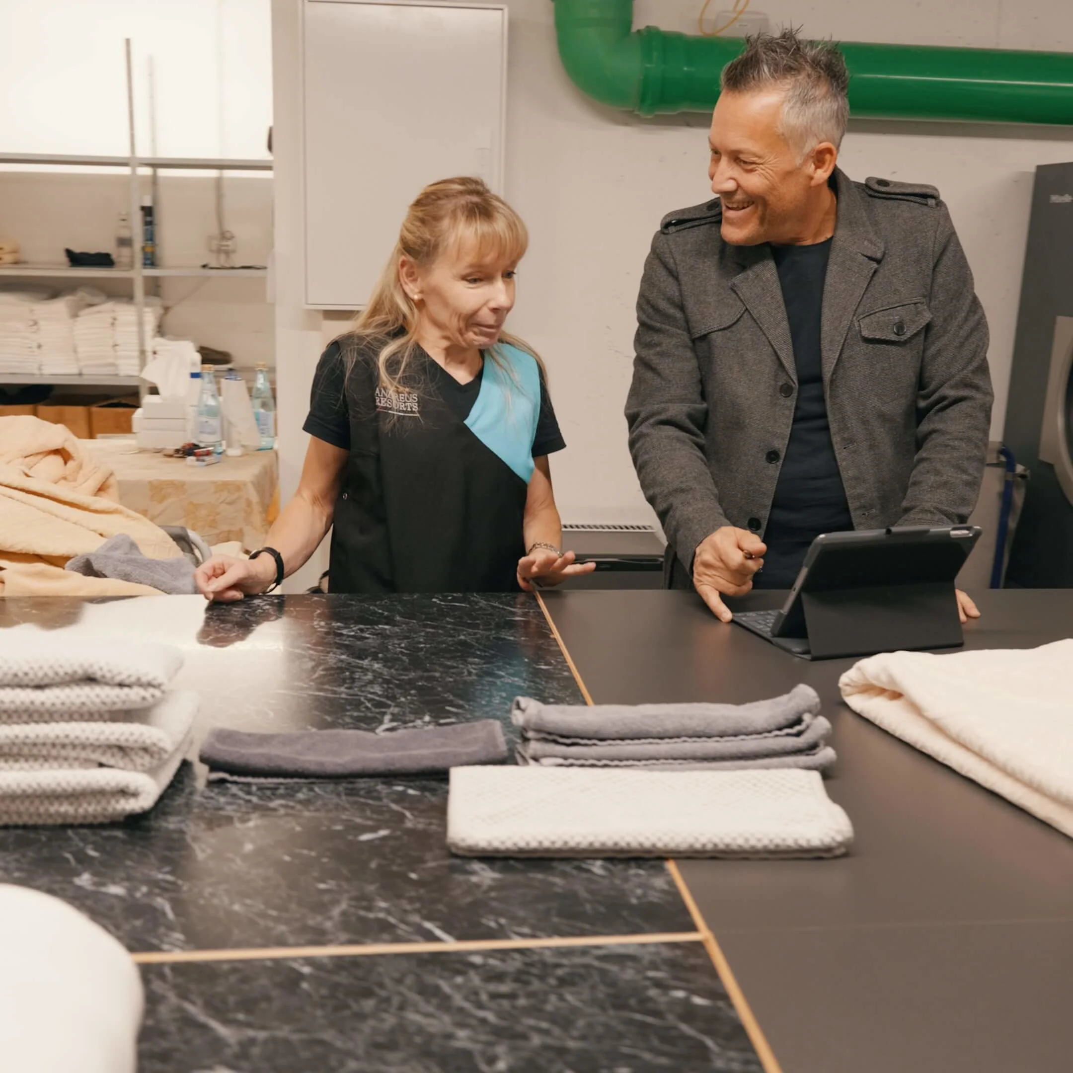 2 personen mit handtüchern und waschmaschine