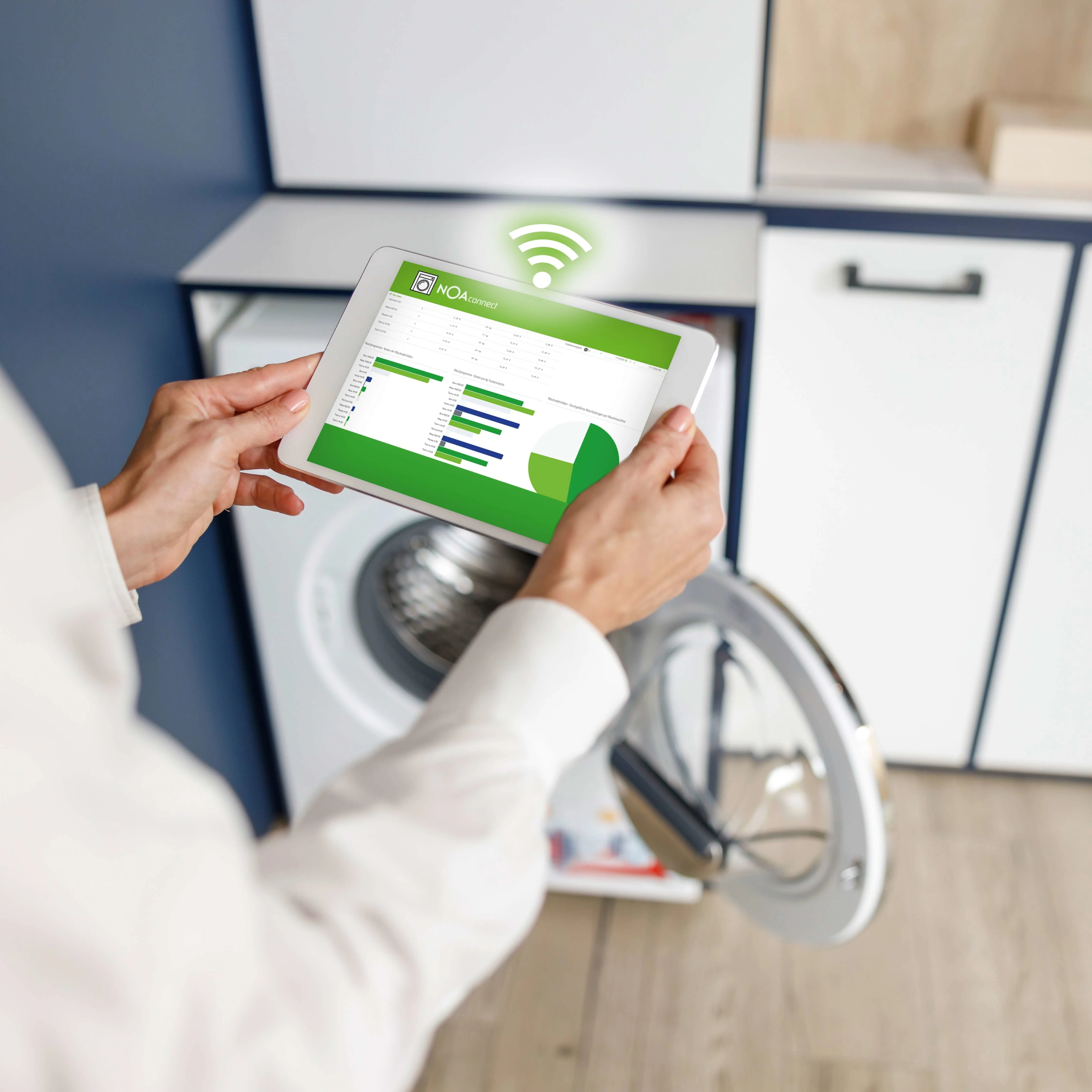 eine person mit tablet vor waschmaschine