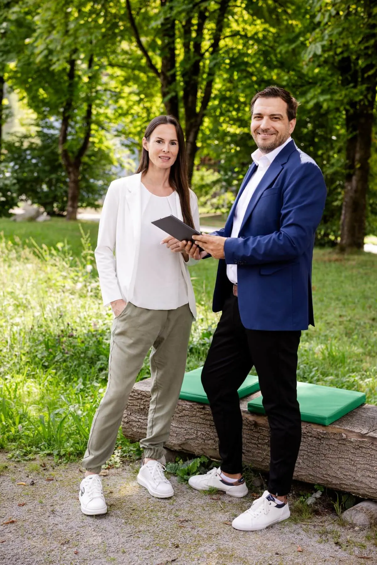 2 personen in einem garten, eine hat ein tablet