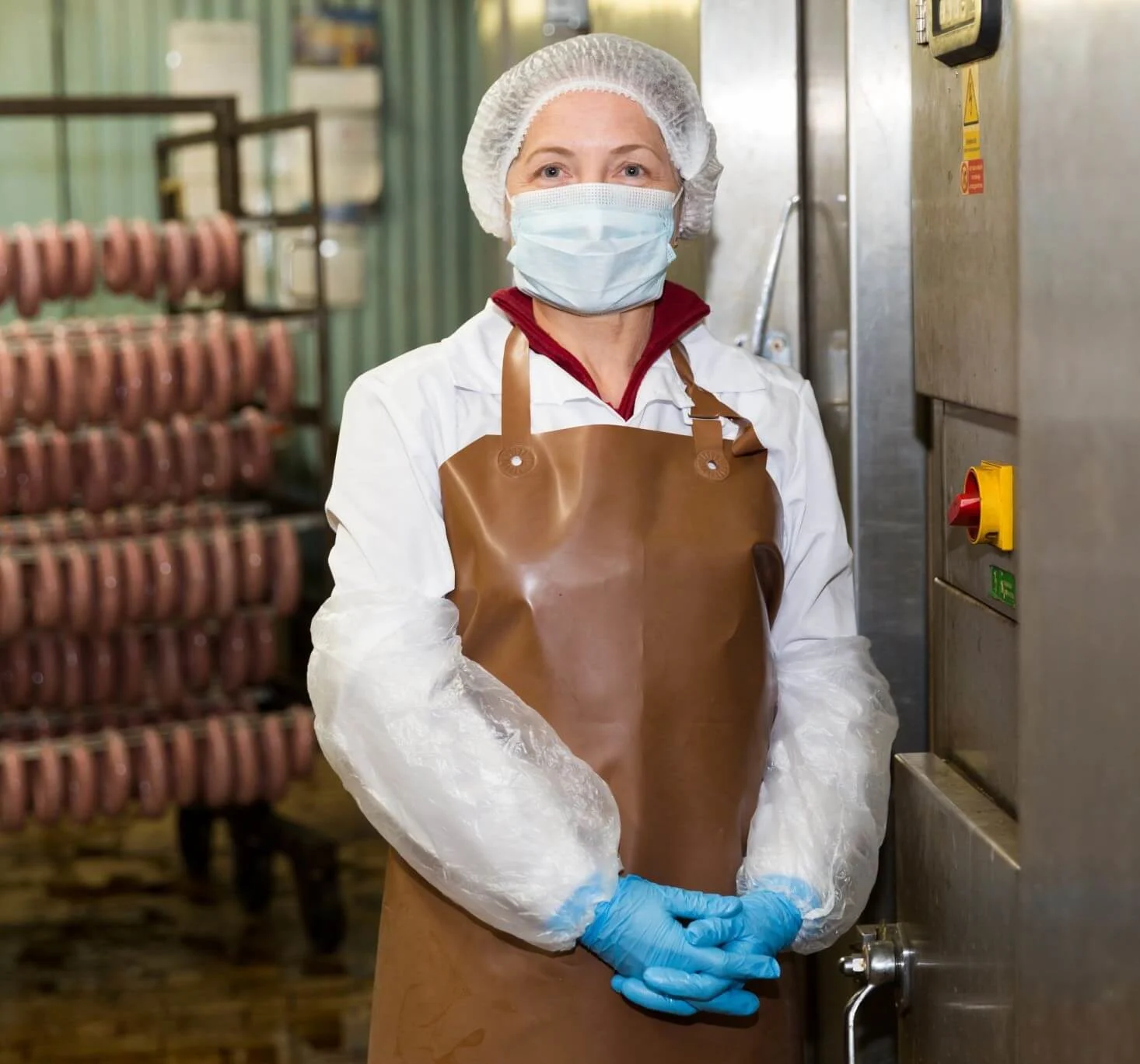 Eine Person mit Mundschutz in Wurstproduktion