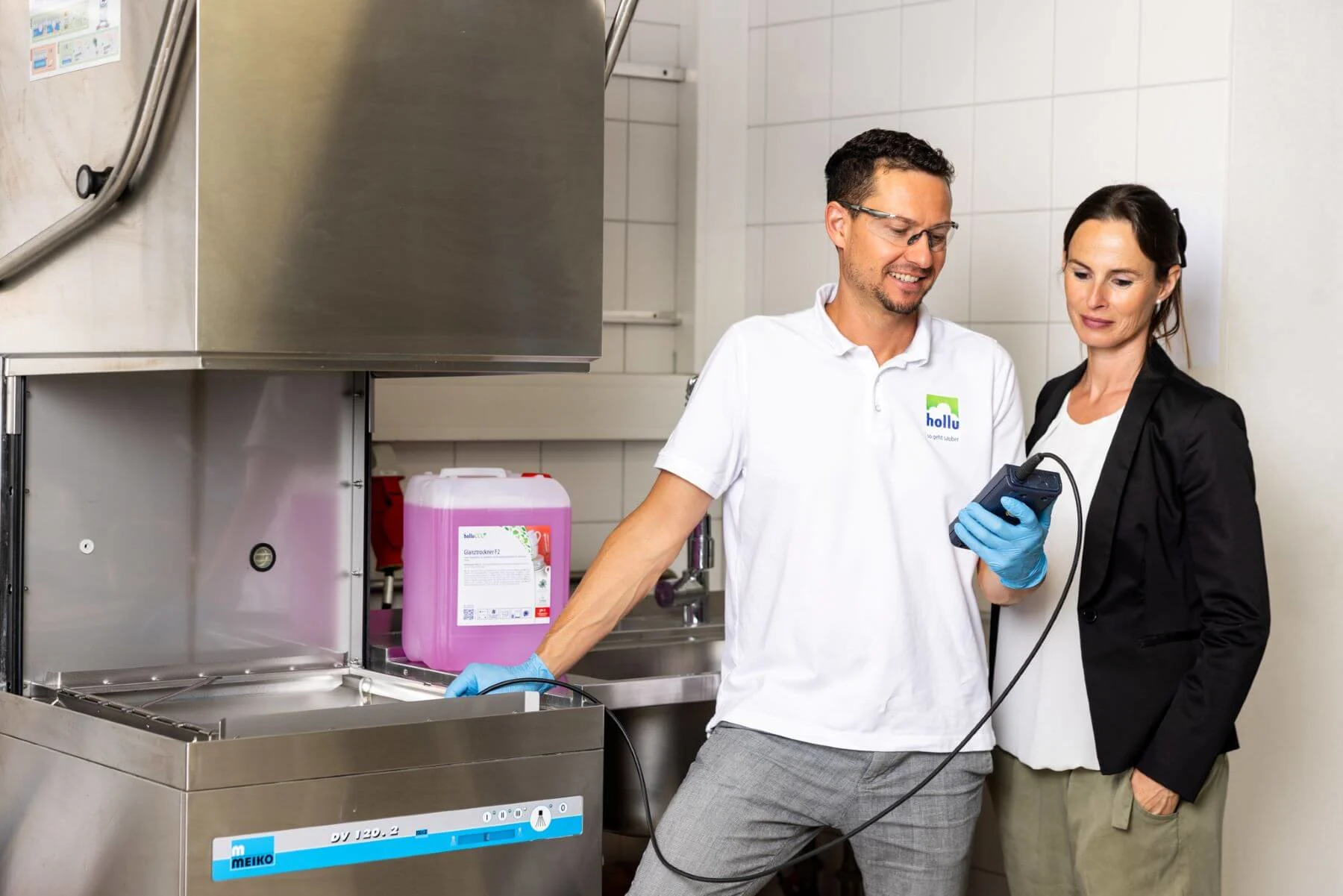 2 personen vor einer gewerblichen spülmaschine