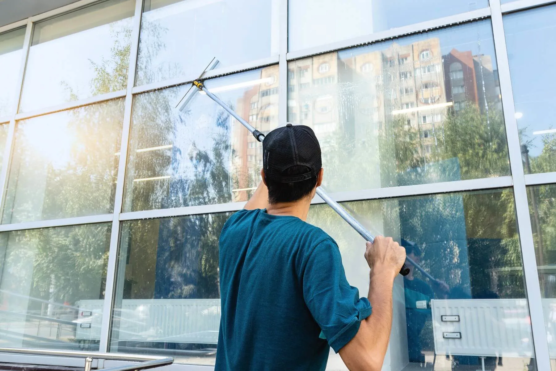 eine person reinigt eine glasfläche
