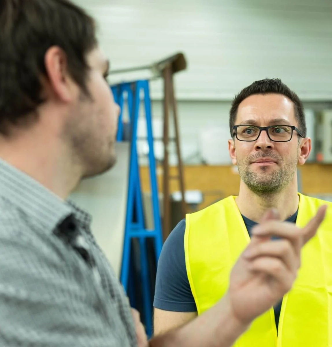 2 personen im gespräch. eine trägt eine warnweste