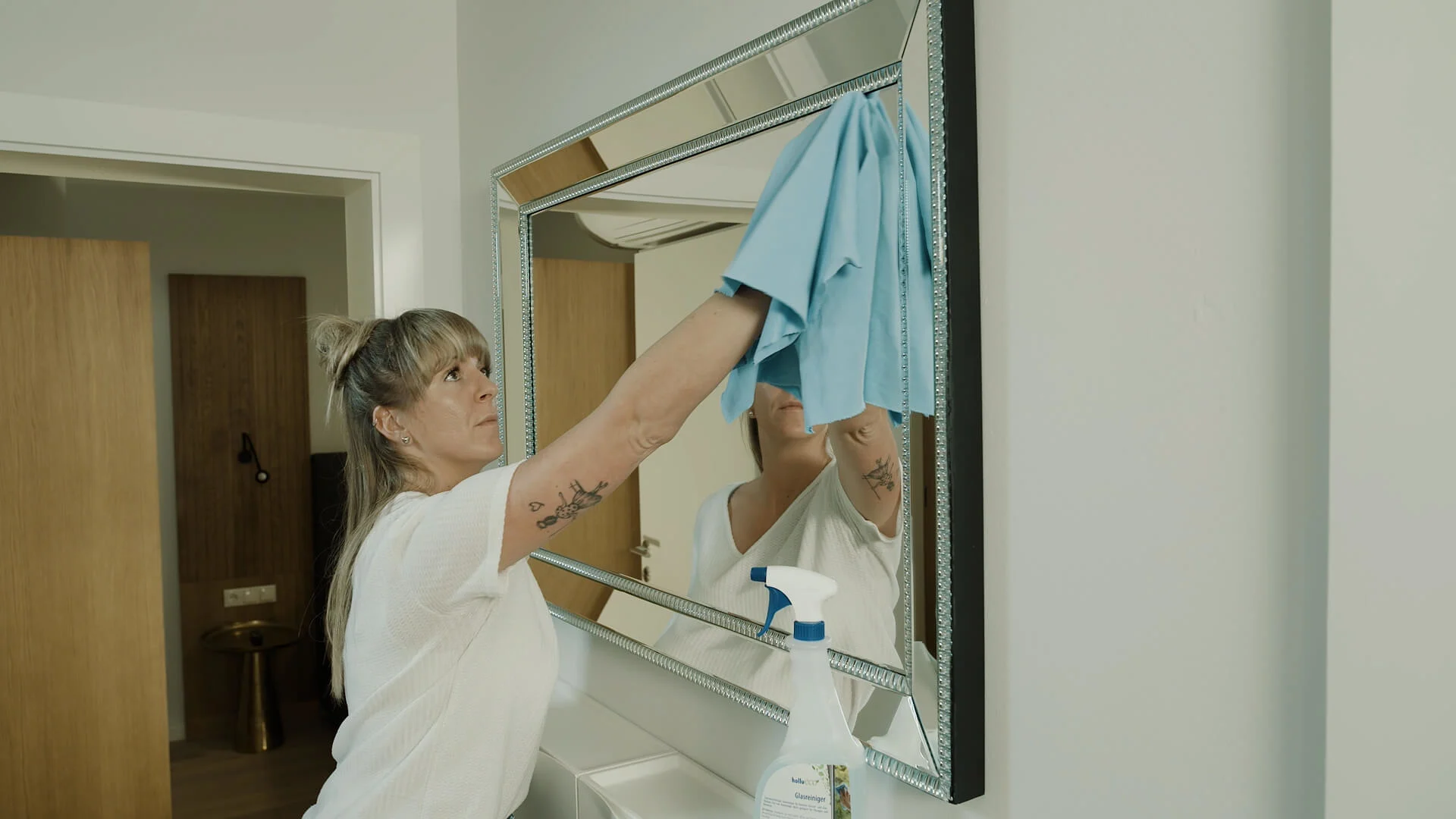 eine person reinigt einen spiegel