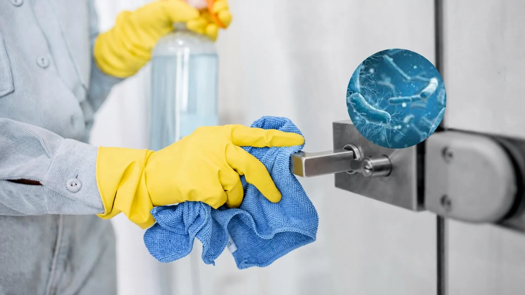 Eine Person reinigt eine Türklinke mit einem blauen Tuch