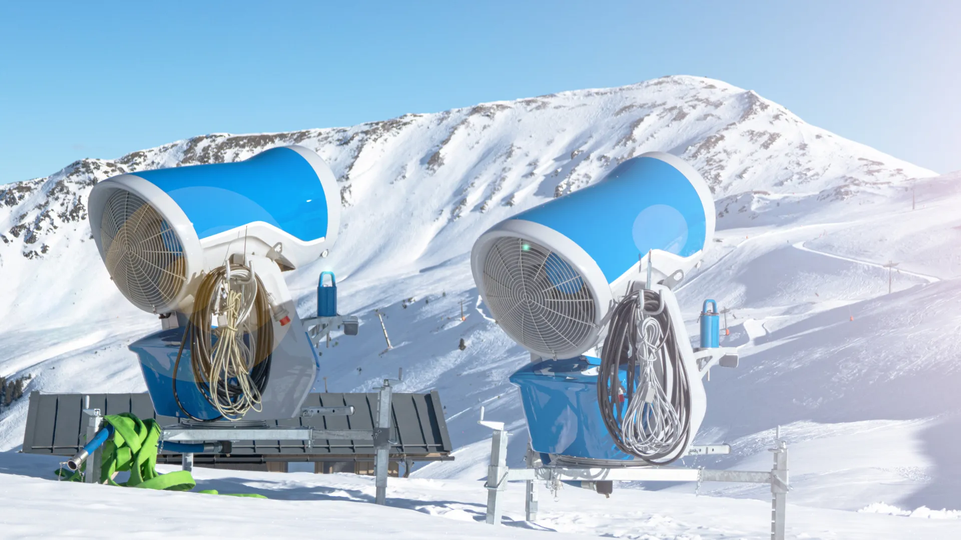 Schneekanonen in Betrieb vor blauem Himmel